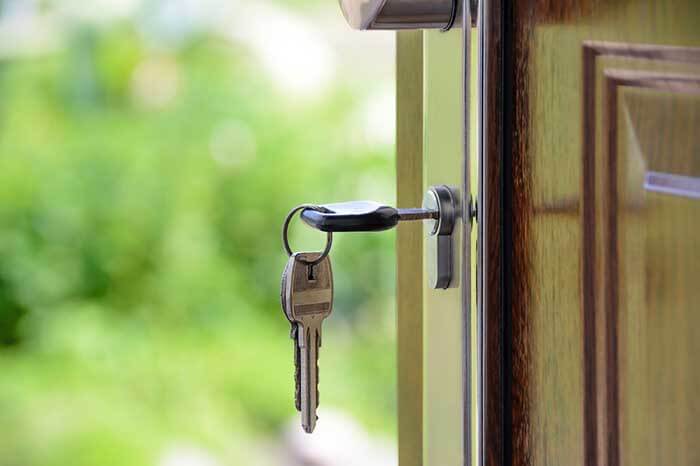 El que es arrendatario abriendo la puerta de casa con la llave